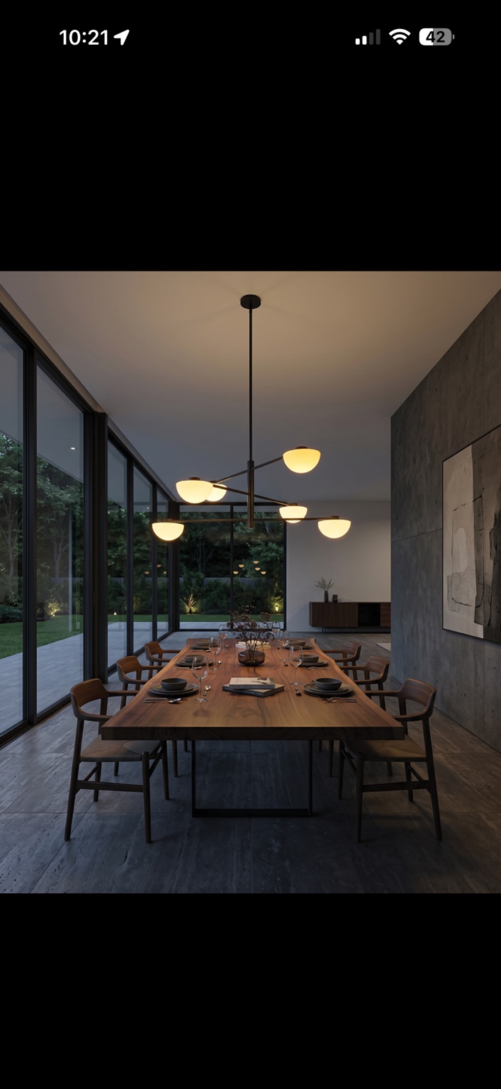 Dark modern dining room with a black branching chandelier and six glowing white bowl lights